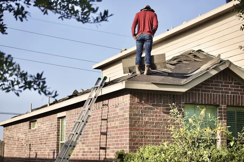 Professional roofer working on a residential roof in Eastmont